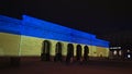 View of ÃâuÃÅ¸eres Burgtor in Vienna, Austria by night with blue and yellow illuminations in the colors of Ukraine during war.